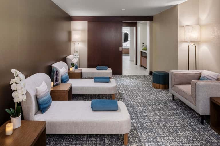 Spa relaxation room with massage chairs, soft lighting, and neutral earth tone decor