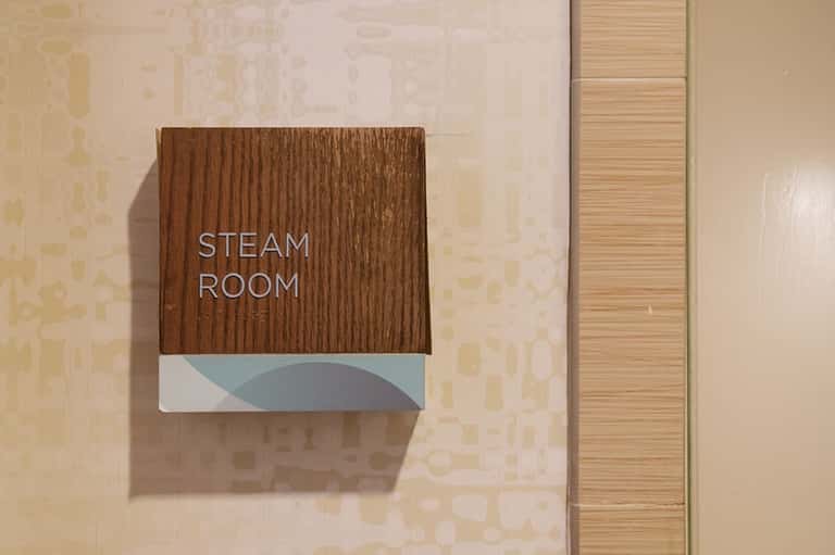 Steam room wooden sign on corridor wall at spa facility