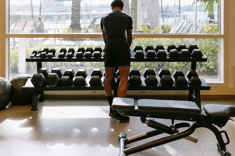 Fitness center with dumbbell rack, exercise equipment, and city skyline views through large windows