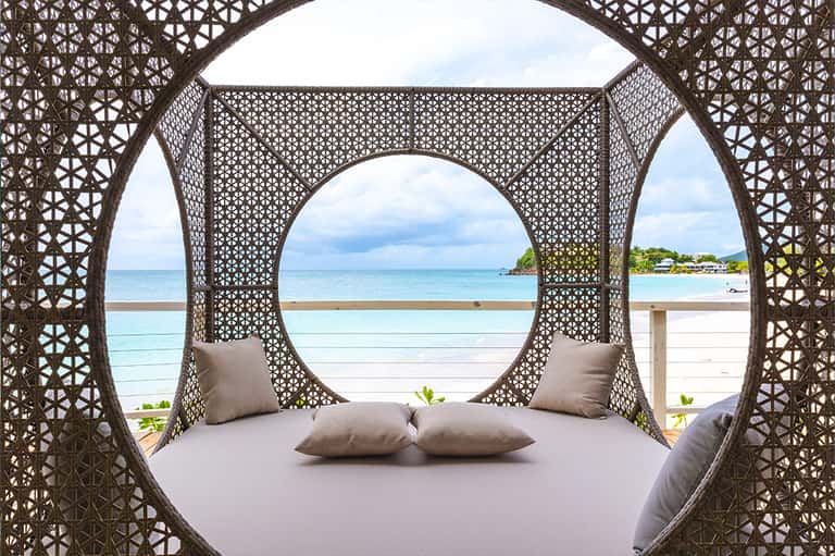 Decorative circular bed canopy with ocean and beach view through latticed frame