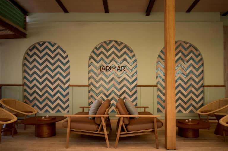 Spa lounge with chevron pattern wall panels, wooden beams, modern chairs, and LARIMAR branding