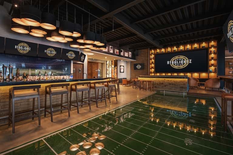 Upscale bar lounge with foosball table, ambient lighting, and bourbon-themed signage and décor