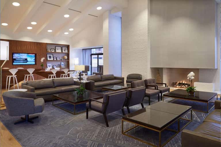 Spacious lobby lounge with high ceilings, fireplace, and modern furniture arrangement