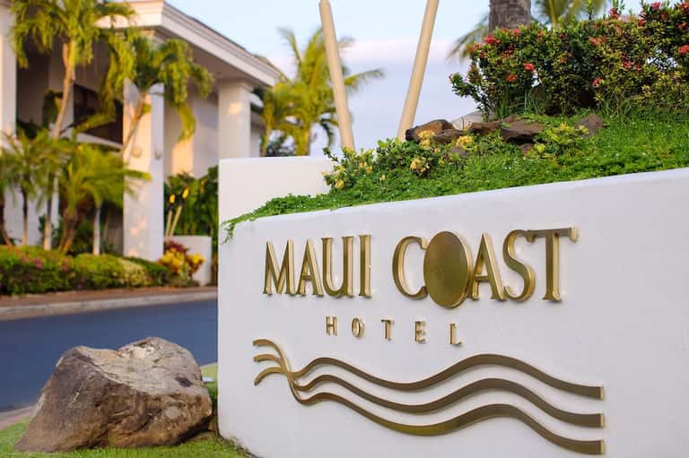 Maui Coast Hotel entrance sign with tropical landscaping and palm trees