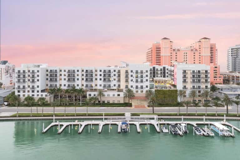 Waterfront resort with marina dock, boats, and sunset sky at dusk