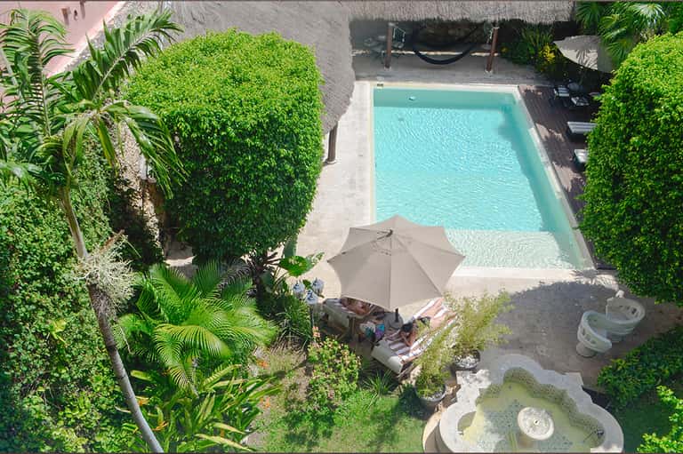 Aerial view of small rectangular swimming pool surrounded by manicured hedges and lounge chairs