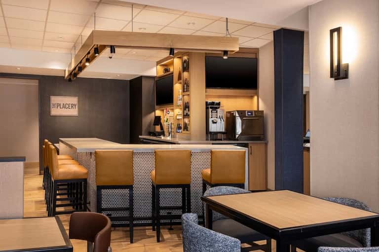 Hotel lounge and bar with wooden accents, tan leather seating, and contemporary design elements