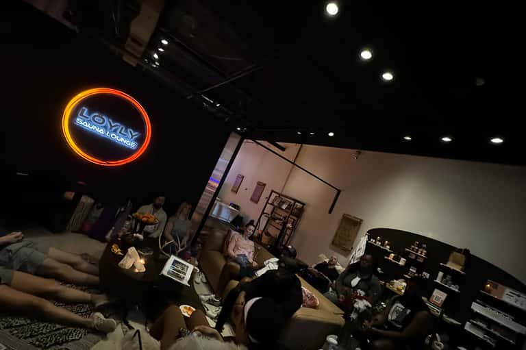 Bowling alley lounge with neon sign, comfortable seating, and casual gathering space