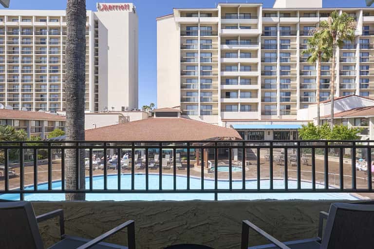 Beachfront Marriott resort viewed from sand with multi-story building and pool visible