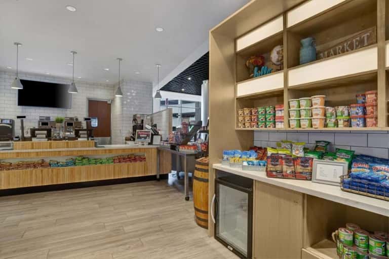 Modern convenience market interior with wood counters, packaged snacks, and refreshment displays