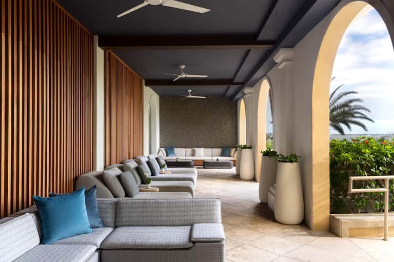 Elegant resort lounge with curved seating, arches, and ocean views