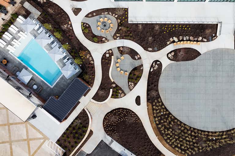 Aerial view of resort courtyard with curved pathways, pool, and landscaped seating areas