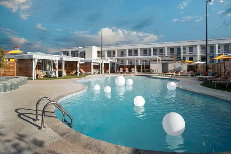 Resort swimming pool with white floating decorative spheres and modern hotel building