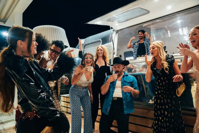 Group of guests celebrating at a food truck serving station at night