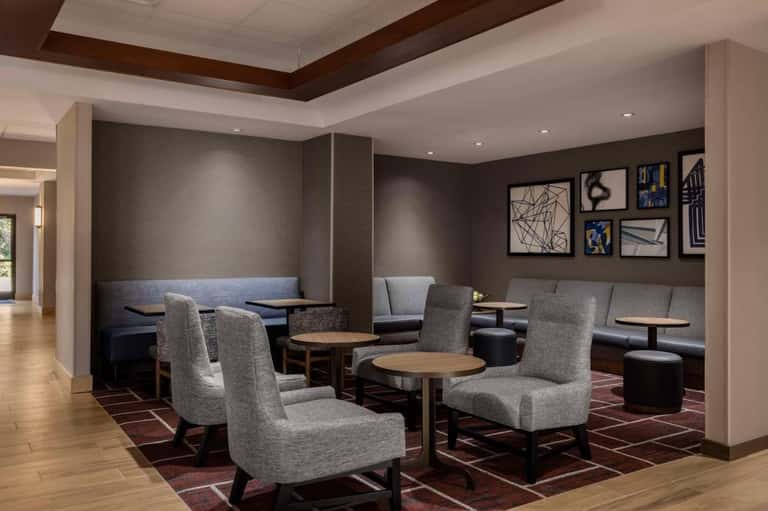 Upscale lounge area with built-in seating, abstract wall art, wooden accents, and neutral color palette