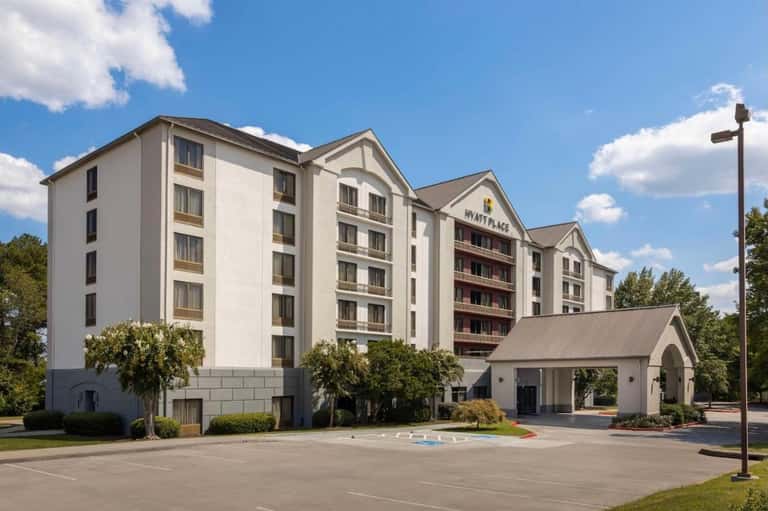 White Wyndham hotel exterior with traditional gable roof design, porte-cochere entry, and landscaping
