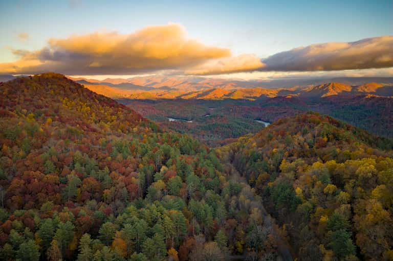Scenic mountain landscape with forested hills and distant valleys at sunset