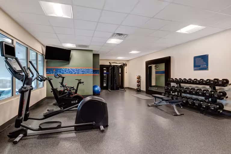 Hotel fitness center with exercise bikes, dumbbells, and gym equipment