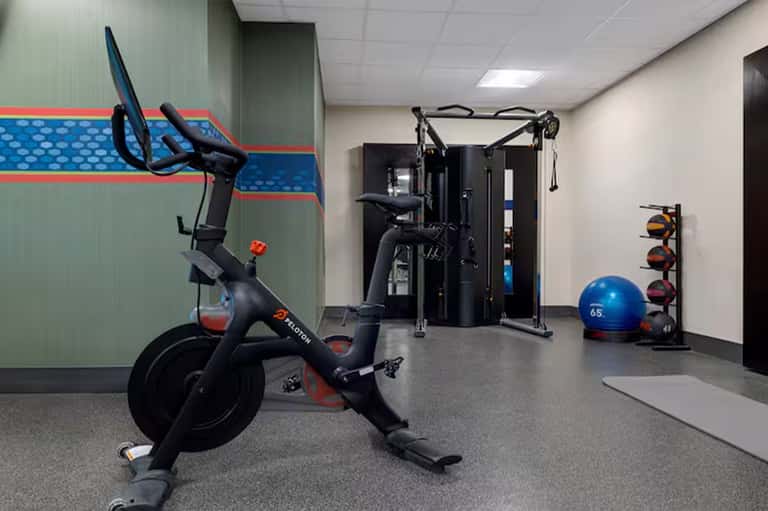 Modern fitness center with exercise equipment including stationary bikes and strength machines