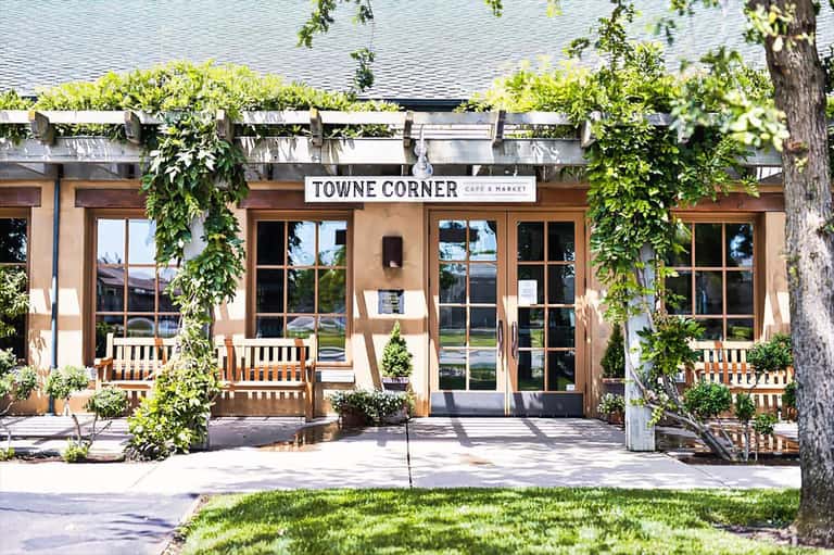 Towne Corner Cafe & Market storefront with ivy-covered entrance and wooden benches