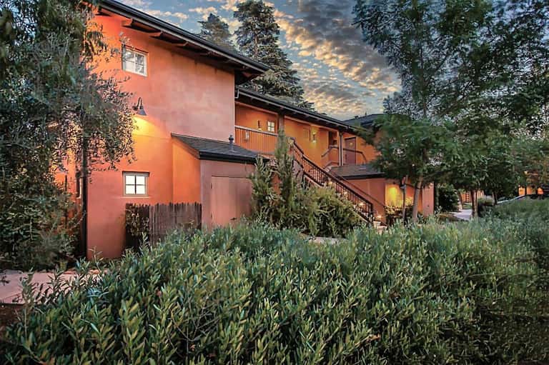 Rustic orange-terracotta building with landscaped gardens at dusk with golden sunset lighting