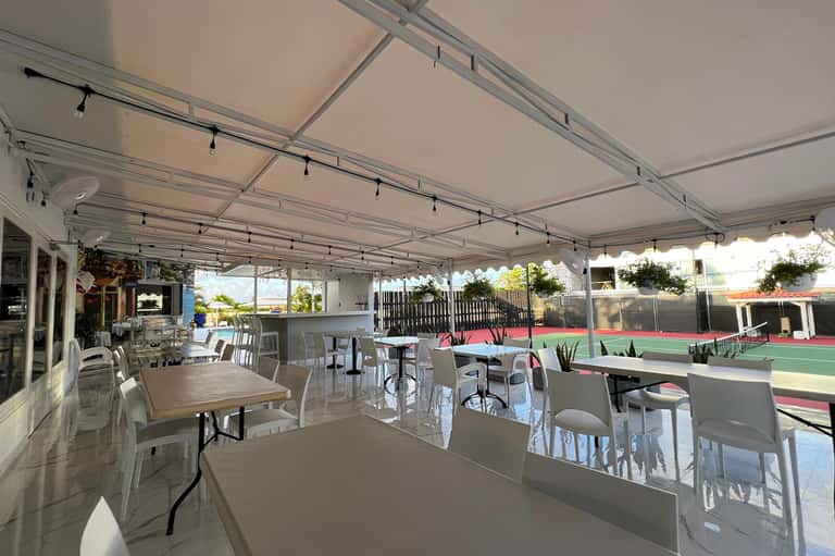 Retractable shade canopy covering outdoor dining and entertainment patio area