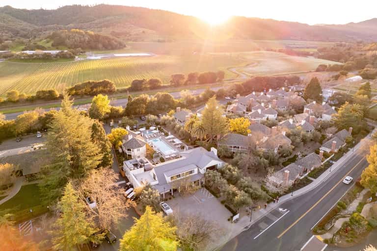 Aerial sunset view of residential neighborhood with vineyards, rolling hills, and valley landscape