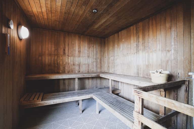 Wooden sauna interior with tiered benches and traditional heated wooden construction