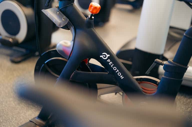 Close-up of Peloton stationary bike with orange accent light in fitness facility