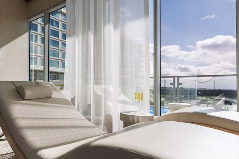 Modern spa relaxation area with lounge chairs and panoramic water views