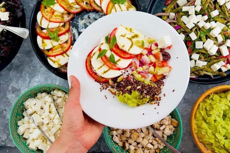 Overhead view of colorful salad plate with ingredients and prepared vegetables