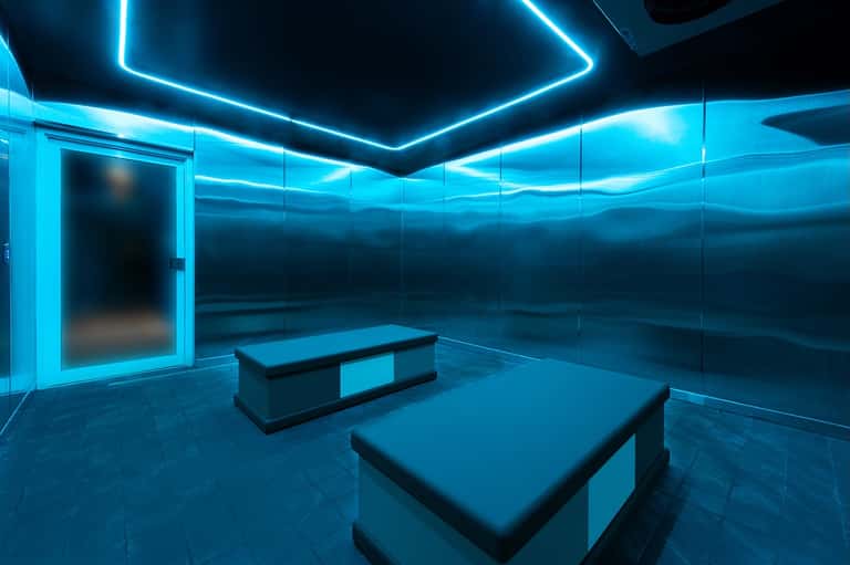 Contemporary blue neon-lit spa or wellness room with massage tables and modern minimalist design
