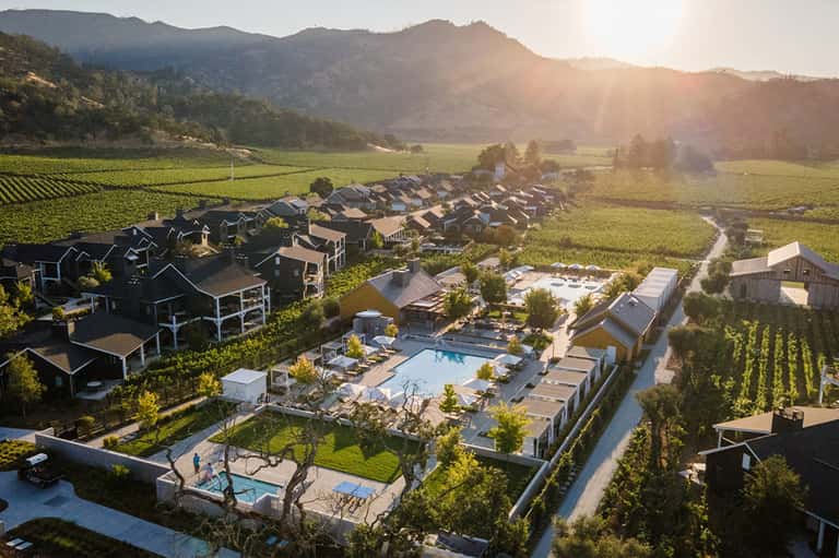 Aerial view of residential resort community nestled in valley vineyard with pools and houses