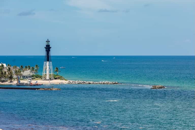 Lighthouse on a tropical beach with turquoise ocean water and white sand