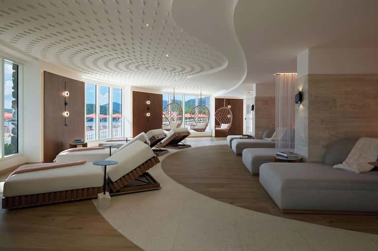 Luxury spa relaxation room with curved ceiling, loungers, and ocean views