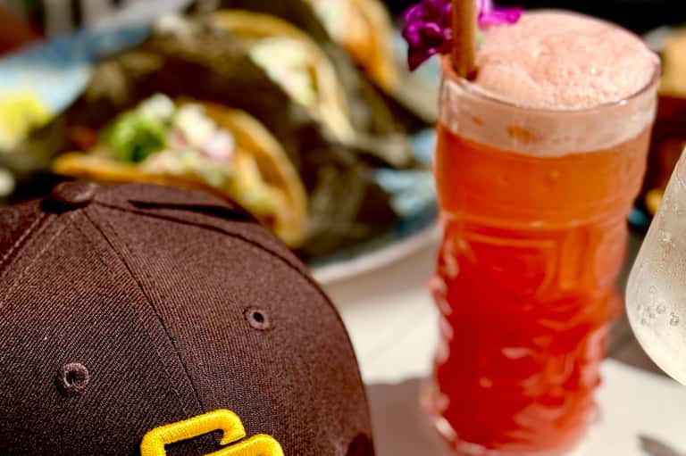 Poolside refreshment with beer and tacos, featuring branded cap and food plating