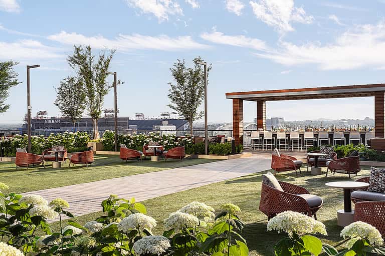 Rooftop terrace with lounge seating, modern pavilion, landscaping, and city skyline views