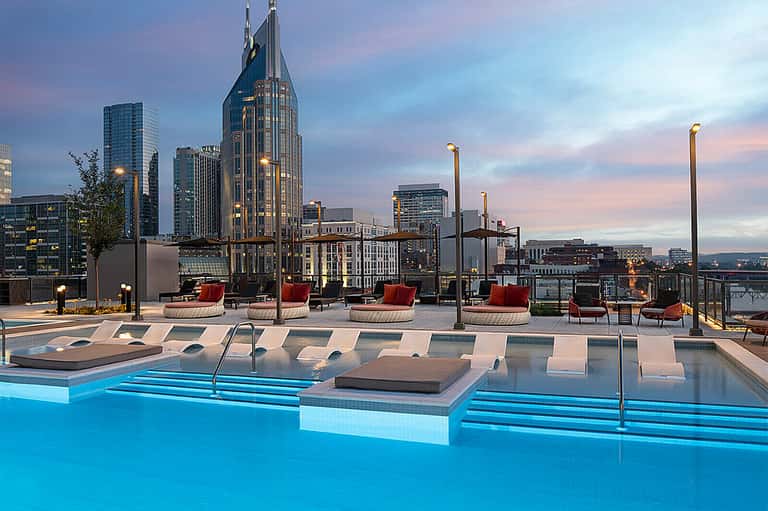 Rooftop pool deck with city skyline views, lounge chairs, and contemporary furnishings