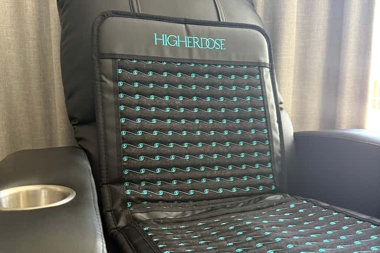 Close-up of HigherDose branded pillow with turquoise pattern on seat