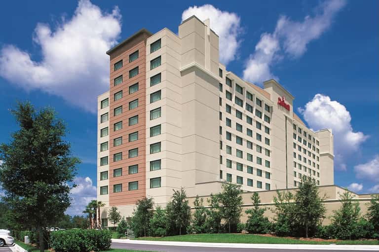 Marriott hotel exterior with red brick and cream colored facade against blue sky with trees