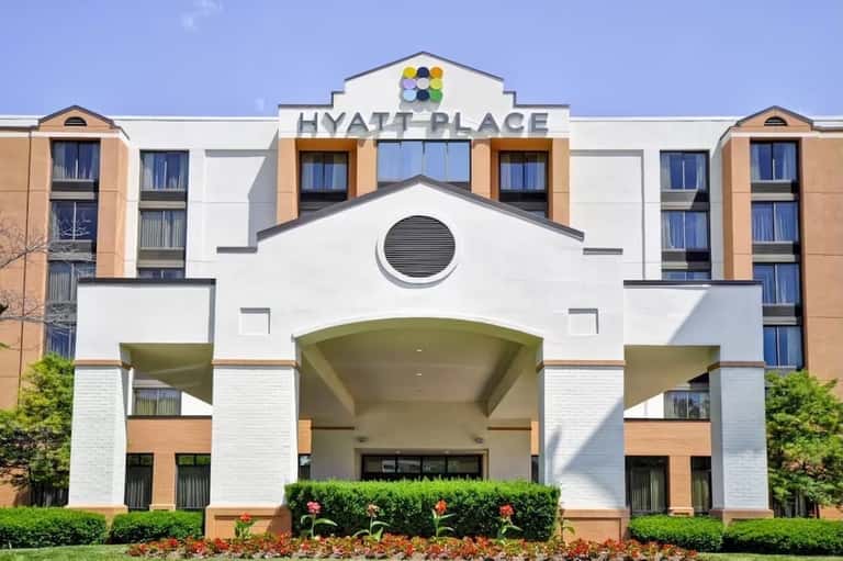 Hyatt Place hotel facade with white and tan modern architecture and manicured landscaping