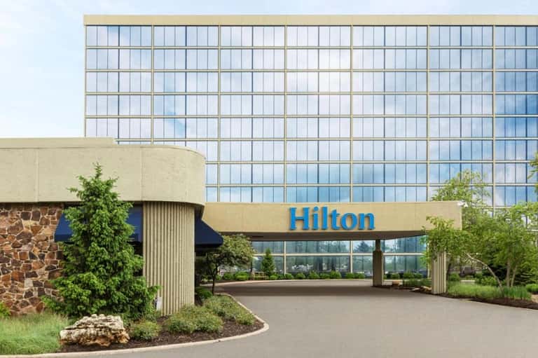 Hilton hotel exterior with modern glass facade and curved stone entrance