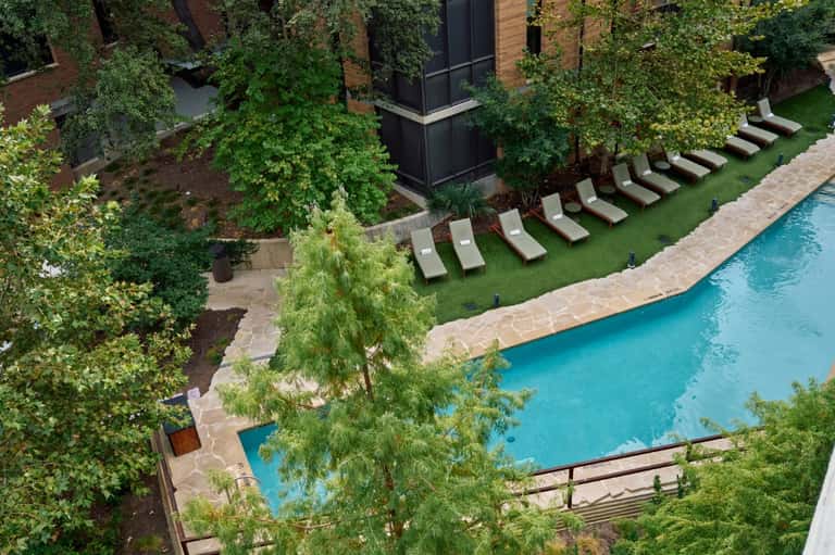 Aerial view of courtyard pool surrounded by lush greenery and modern architecture