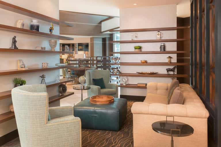 Upscale lounge with floating wood shelves, contemporary furniture, and decorative accessories