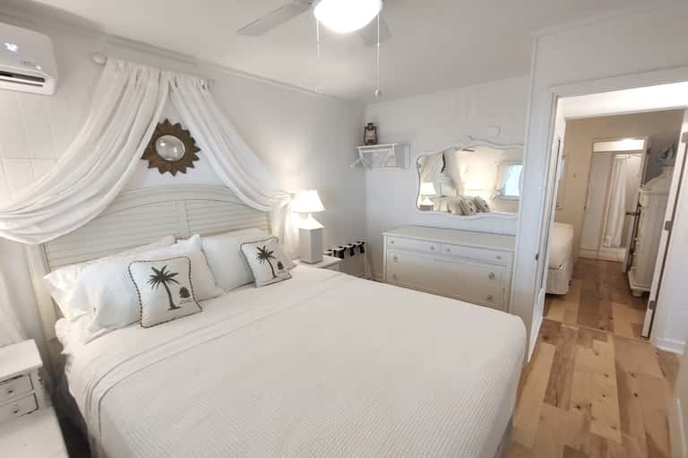 Coastal-themed bedroom with canopy bed and white furnishings
