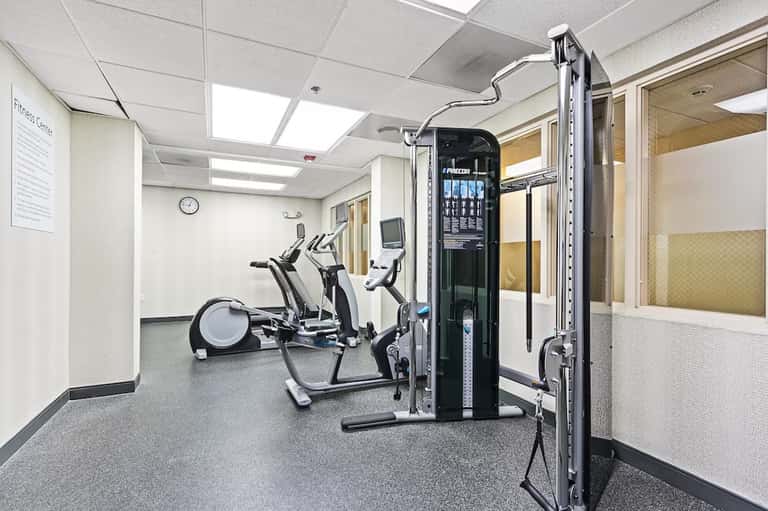 Hotel fitness center with exercise equipment including elliptical machines and weight training apparatus