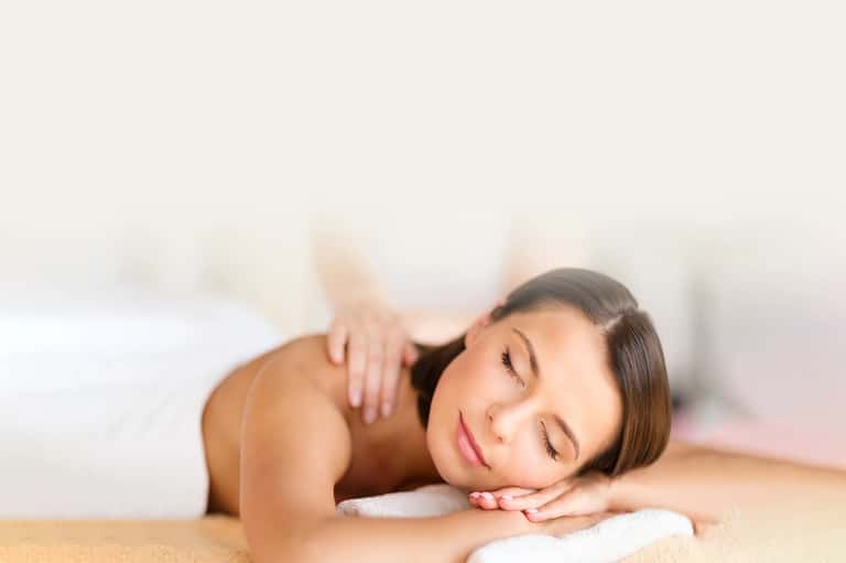 Woman receiving spa massage on treatment table in wellness facility