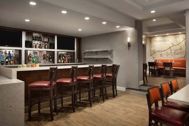 Upscale bar and lounge with dark wood, burgundy seating, and decorative map