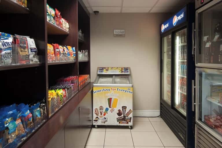 Hotel market interior with snack shelves, beverage coolers, and vending machines