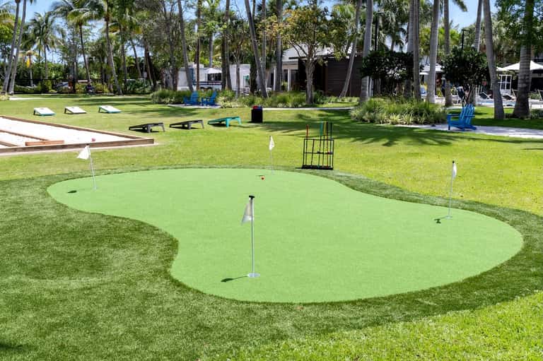 Resort grounds featuring mini-golf course with palm trees and tropical landscaping